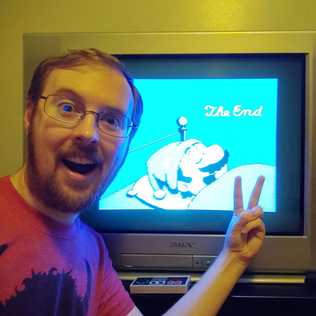 A photo of Tylor in front of a CRT displaying the end screen of Super Mario Bros. 2 for the NES
